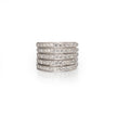 A stack of five slim diamond pave rings in a silver-toned metal, arranged vertically on a clean white background with a soft reflection below.