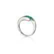 A platinum ring featuring a curved top set with three small vibrant green gemstones, shown on a clean white background with a soft reflection below.