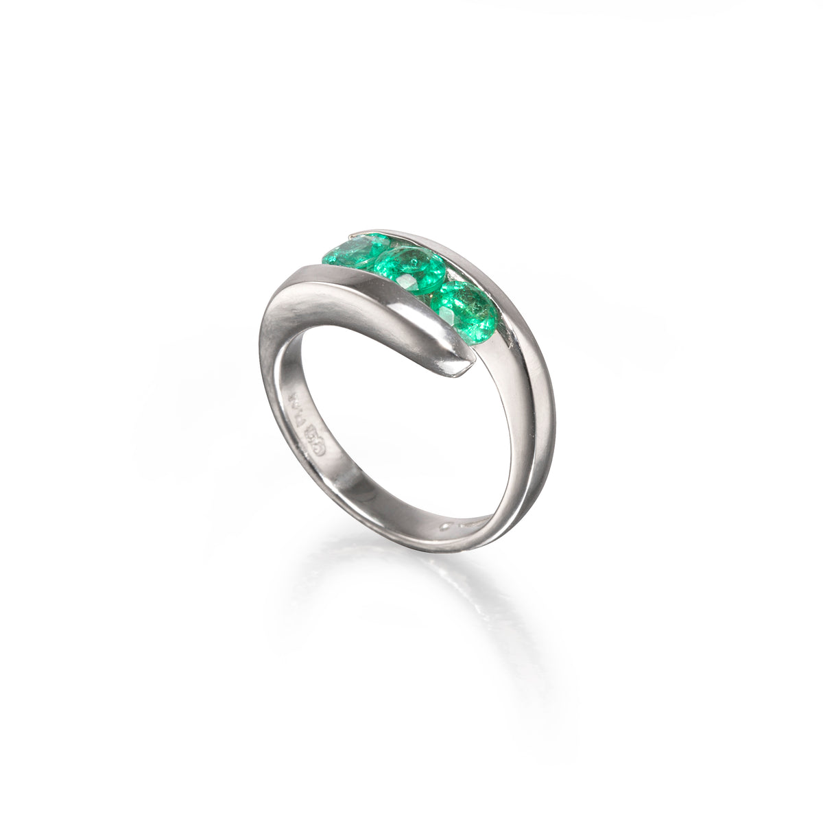 A platinum curved ring featuring a row of vibrant green emerald-cut gemstones across the top, displayed on a clean white background with a soft reflection.