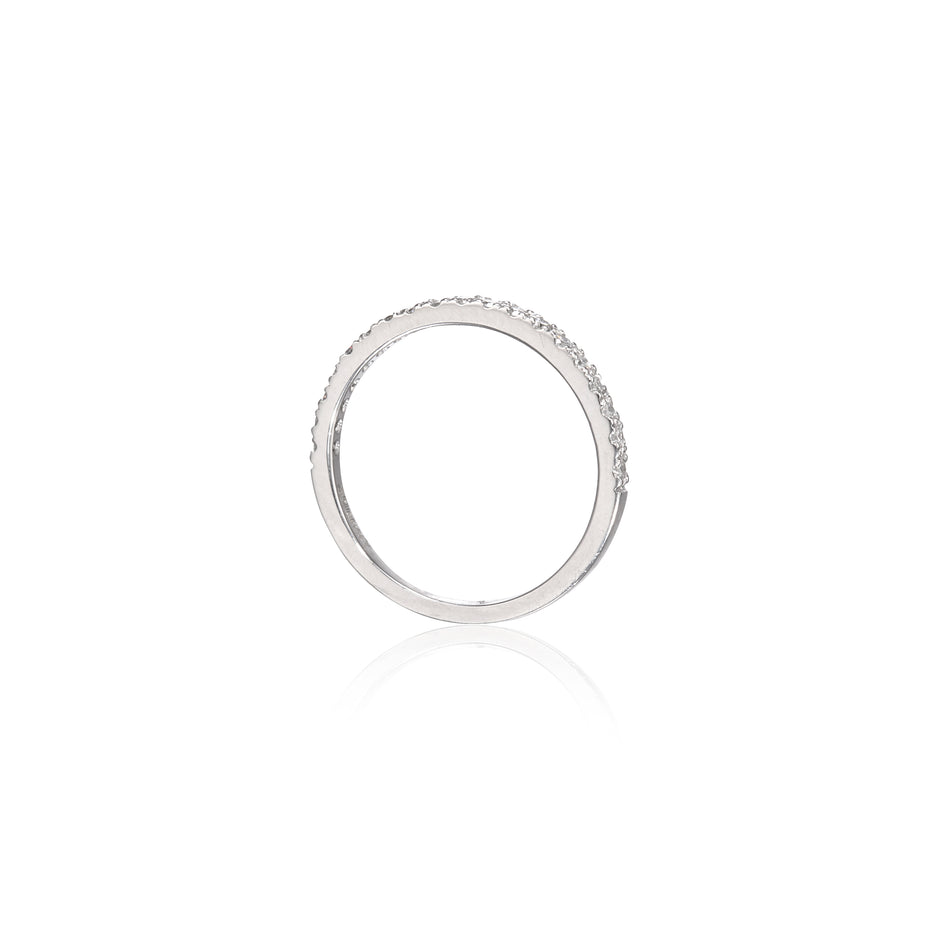 A white gold eternity ring with a continuous row of small clear stones, shown on a clean white background with a soft reflection below.