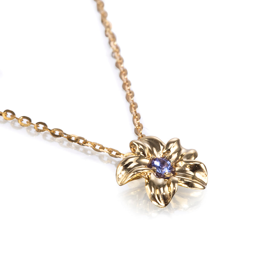 A gold flower pendant necklace with a small purple gemstone in the center, shown on a clean white background.