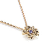 A gold flower pendant necklace with a small purple gemstone in the center, shown on a clean white background.