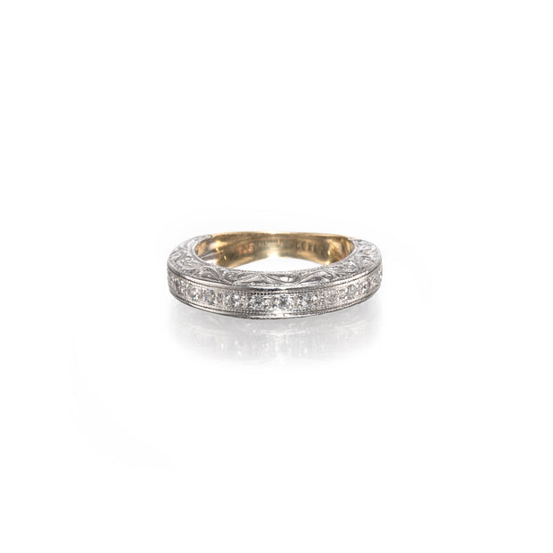 A vintage-style diamond band ring with a yellow gold inner band and a white gold outer band paved with small clear stones, shown on a white background with a soft reflection.