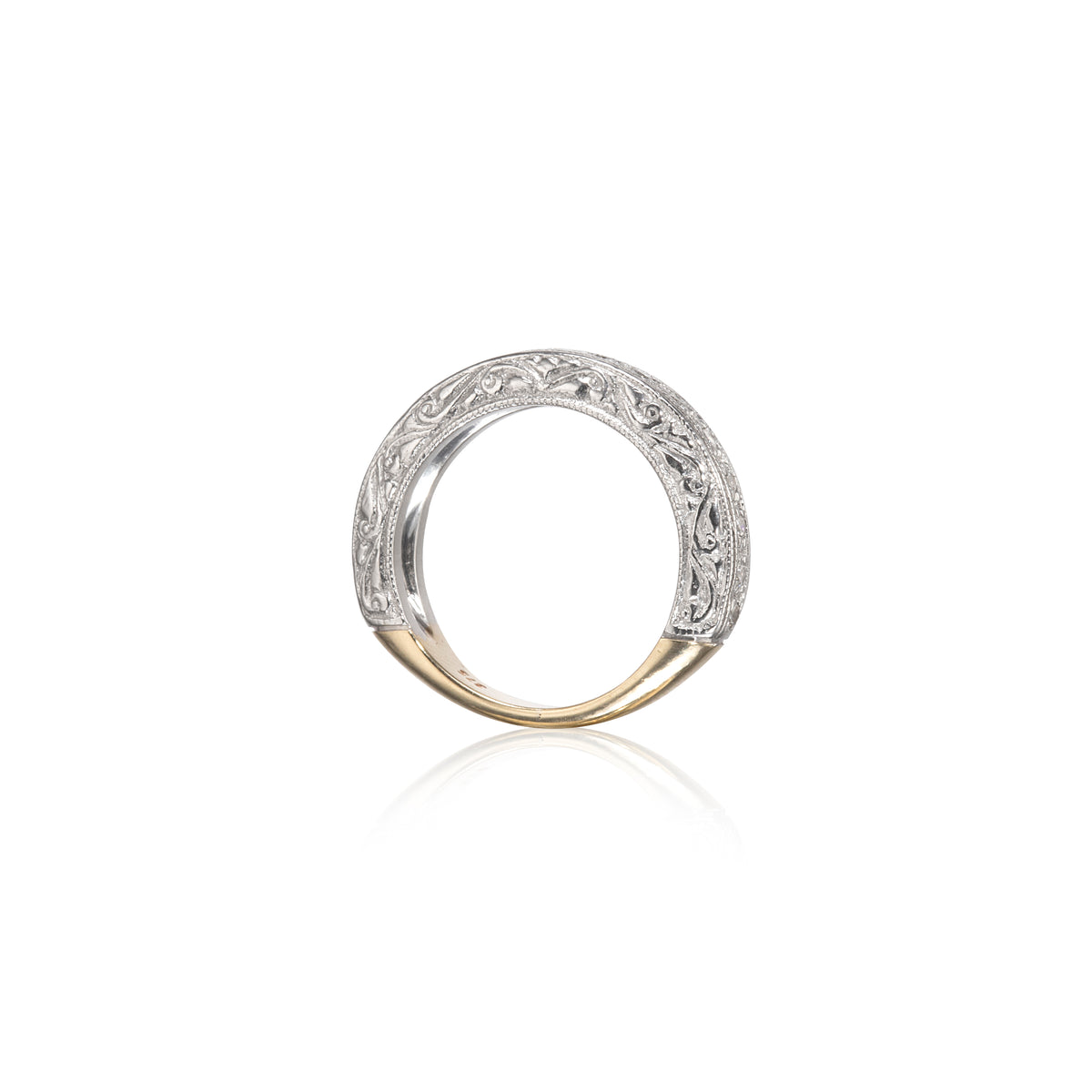A two-tone ring featuring a white gold filigree band with a polished yellow gold base, shown on a clean white background with a soft reflection.