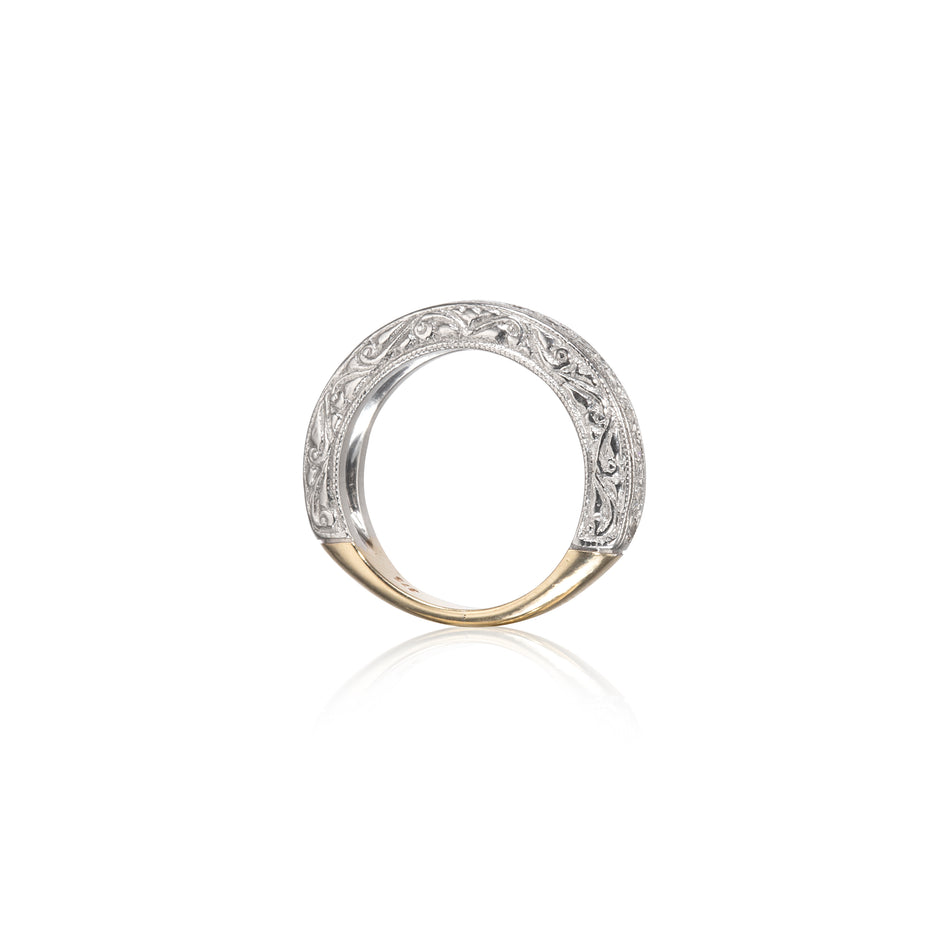 A two-tone ring featuring a white gold filigree band with a polished yellow gold base, shown on a clean white background with a soft reflection.