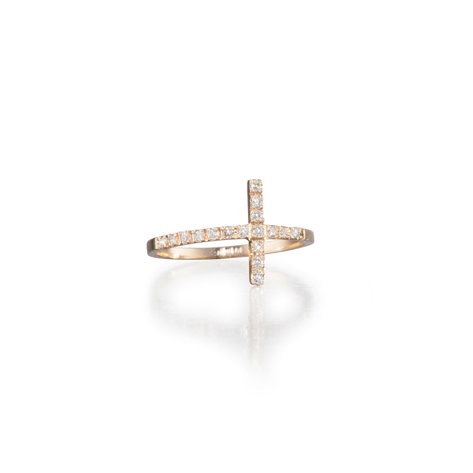 Gold cross-shaped ring with embedded diamonds on a white background