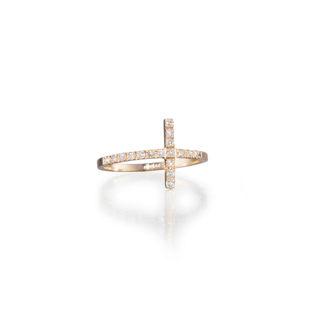 Gold cross-shaped ring with embedded diamonds on a white background