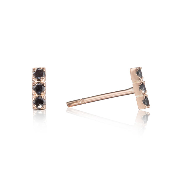 Rose gold earrings with black gemstones on a white background