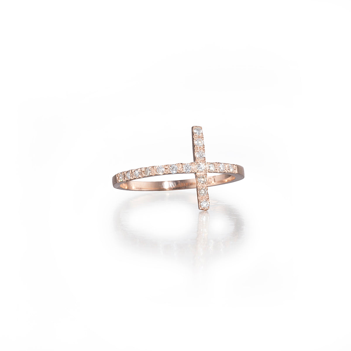 Rose gold ring with diamond cross design on a white background