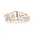 A double-strand pearl bracelet with a polished silver clasp, displayed on a clean white background with a soft reflection.