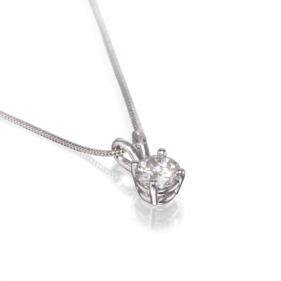 A white gold diamond pendant necklace on a delicate chain, set against a clean white background with a soft reflection.
