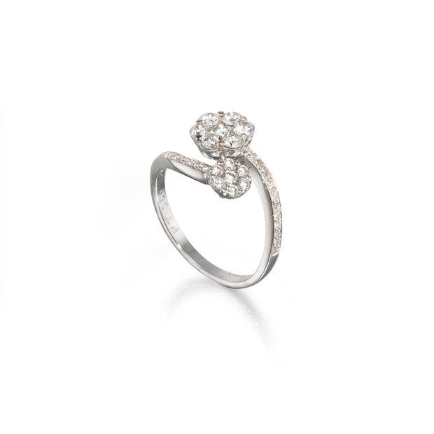 A platinum diamond ring with a heart-shaped cluster of clear gemstones on the top and a pavé-set diamond band, shown on a clean white background with a soft reflection.