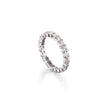 A platinum eternity ring set with small clear round-cut stones, shown at an angle on a clean white background with a soft reflection below.