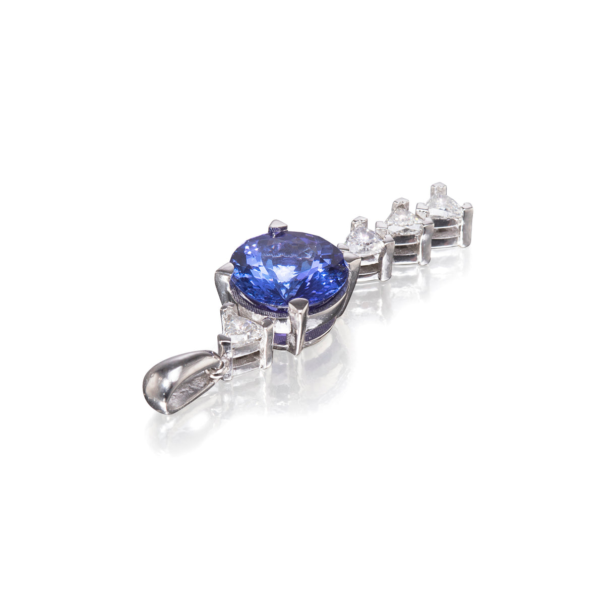 A platinum pendant featuring a large oval-cut blue sapphire center stone, accented by small clear round-cut diamonds along a curved setting, shown on a white background with a soft reflection.