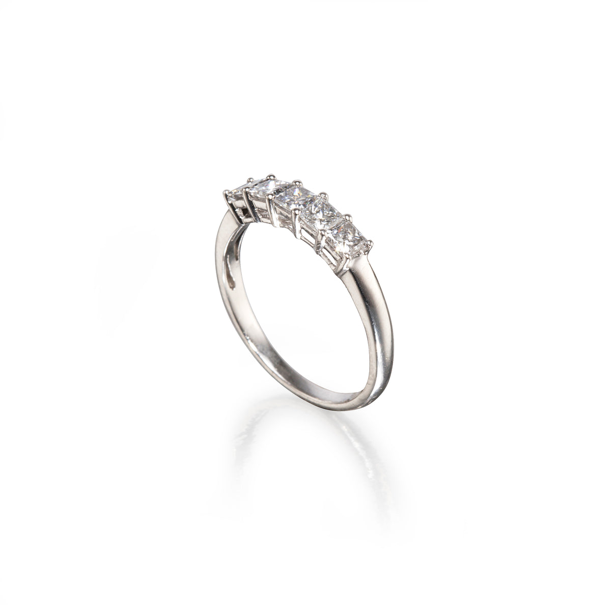 A platinum five-stone diamond ring with a polished band and a row of clear round-cut diamonds, shown on a white background with a soft reflection.
