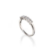 A platinum five-stone diamond ring with a polished band and a row of clear round-cut diamonds, shown on a white background with a soft reflection.