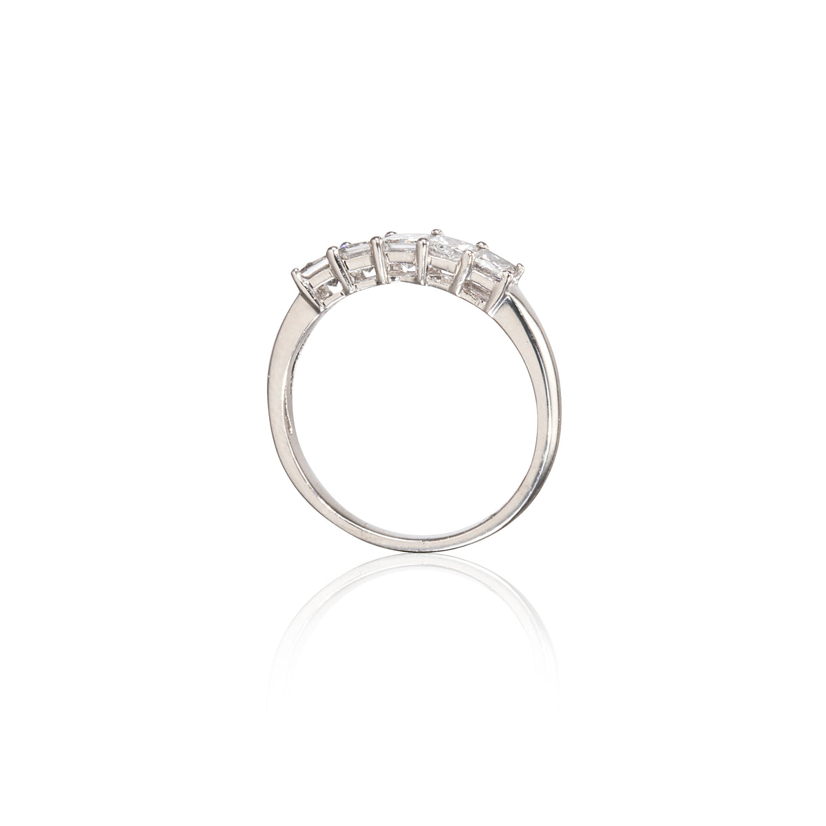 A platinum ring with a row of clear rectangular gemstones on the band, shown against a plain white background with a soft reflection below.