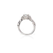 A platinum diamond ring with a central round-cut diamond and smaller diamonds along the shoulders, shown on a clean white background with a soft reflection below.