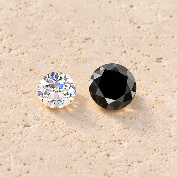 Two round brilliant-cut gemstones on a textured beige stone surface: one clear white diamond and one black diamond.