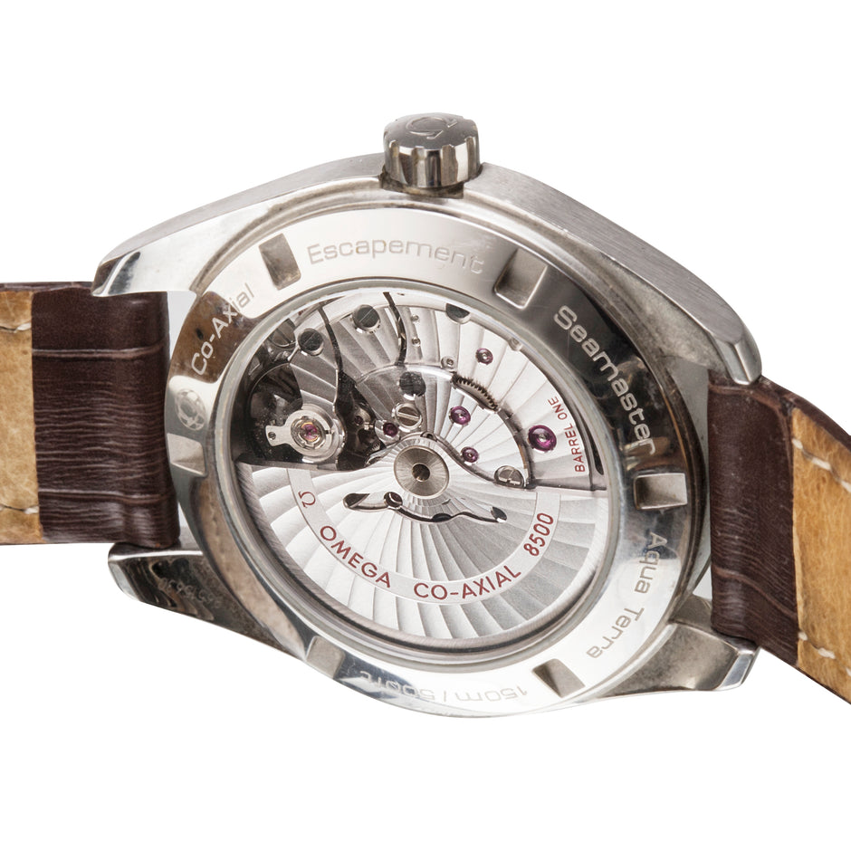 Close-up of a wristwatch back case showing the exposed mechanical movement, with a brown leather strap visible on both sides against a white background.