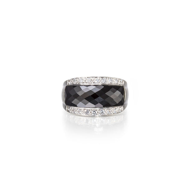 Ring with black gemstone and diamond-studded band on a white background