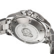 Close-up of the back case of a stainless steel wristwatch, showing engraved text and a logo mark on a clean white background.