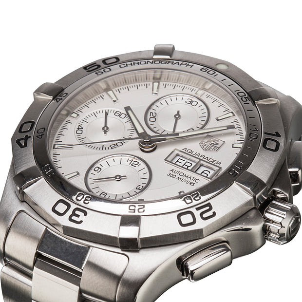 A close-up shot of a TAG Heuer Aquaracer automatic chronograph watch with a silver stainless steel case, white dial, and integrated link bracelet on a white background.