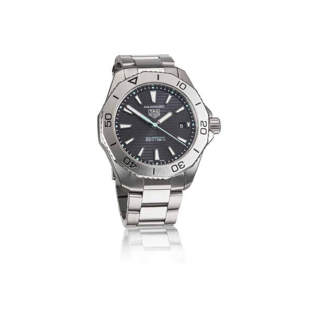TAG Heuer Calibre Oyster watch with a stainless steel link bracelet, featuring a dark gray dial, silver bezel, and white hour markers, shown on a white background with a subtle reflection.