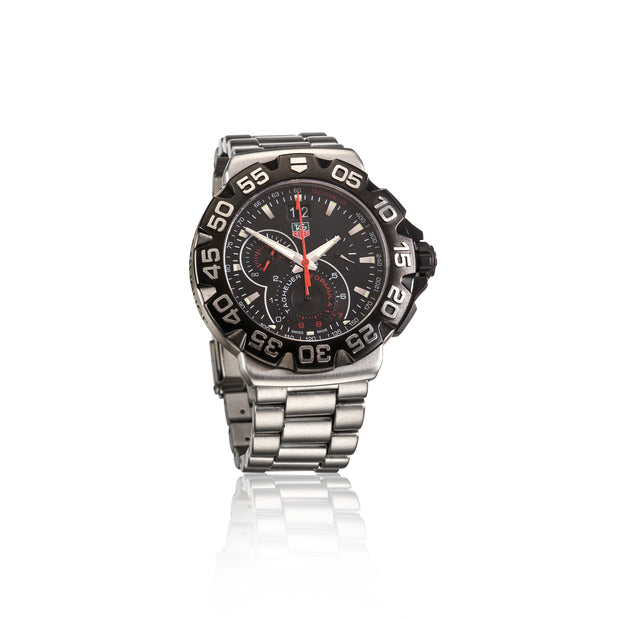 A stainless steel chronograph watch with a black dial, black bezel, and stainless steel bracelet, featuring white and red accents on the face.