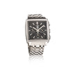 A silver-tone stainless steel watch with a square bezel, black dial, and a checkered metal link bracelet, shown on a white background with a faint reflection.