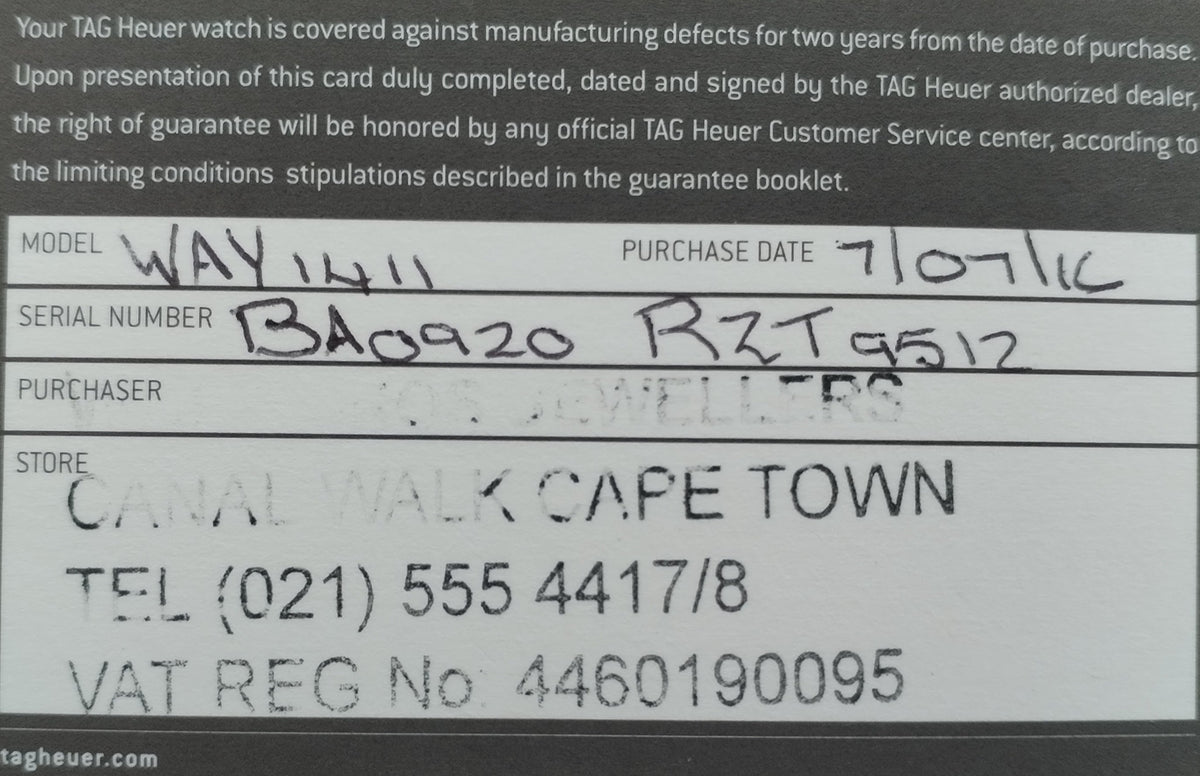 A close-up of a TAG Heuer watch warranty card with printed and handwritten text