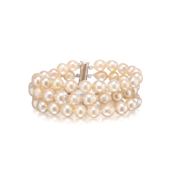 A multi-strand pearl bracelet with a silver-toned clasp, displayed on a clean white background.