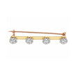 A gold and rose gold bar brooch featuring four round-cut clear gemstones, set against a plain white background.