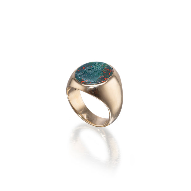 Gold ring with a circular stone on a white background