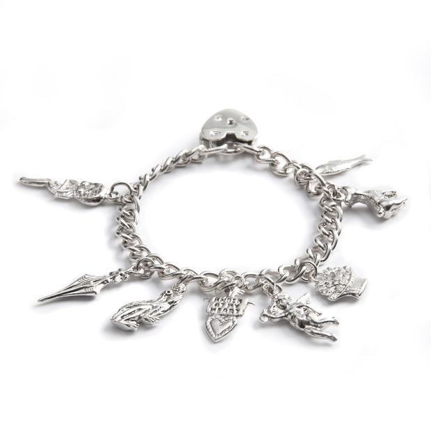 Silver charm bracelet with various charms on a white background
