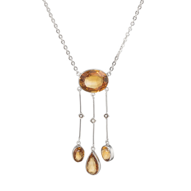 Necklace with amber-colored pendant and teardrop-shaped stones on a white background
