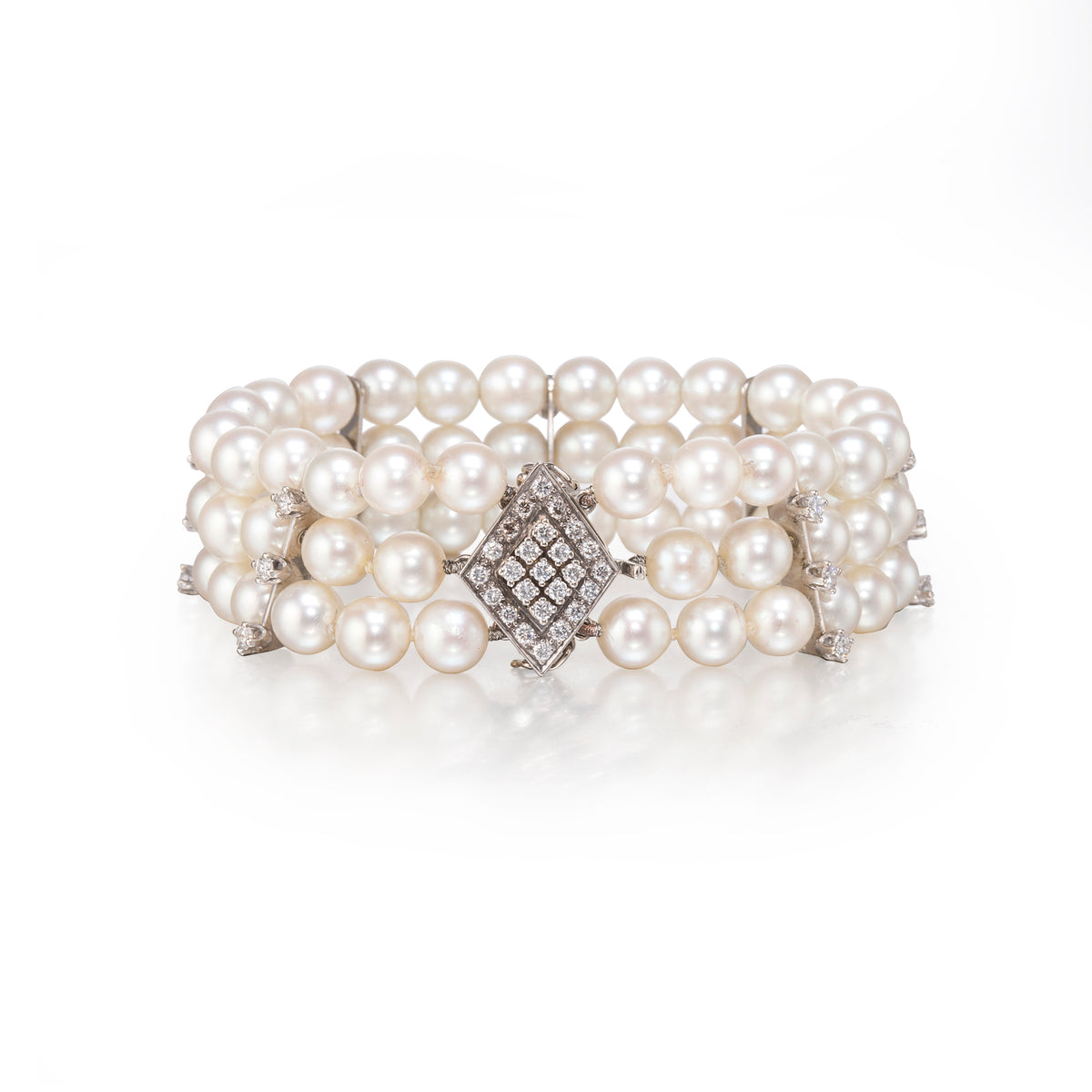 Pearl bracelet with diamond clasp on a white background
