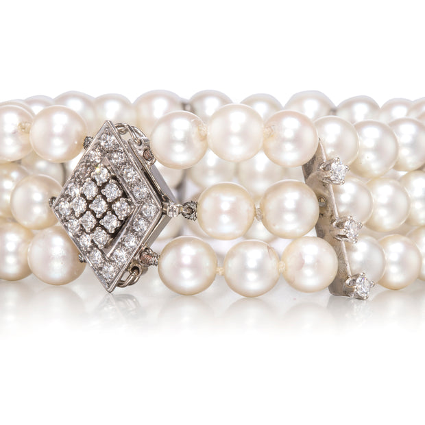 Pearl necklace with diamond clasp on a white background